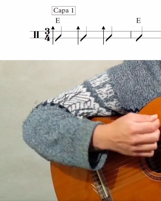 La mano derecha rasgueando, con la partitura de la capa 1