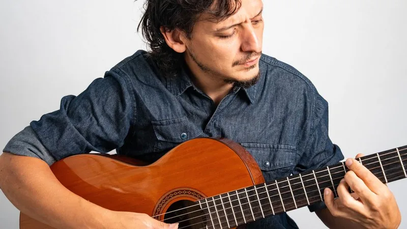 Juan Nieva tocando guitarra concentrado